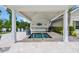 Covered hot tub with tile surround, lighting, and adjacent counter space for convenient poolside refreshments at 1957 Indigo Cove Ln, Calabash, NC 28467