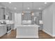 Modern kitchen featuring grey cabinetry, stainless steel appliances, and a large center island with quartz countertops at 1957 Indigo Cove Ln, Calabash, NC 28467