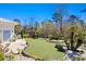 Lush putting green surrounded by landscaping including tropical plants and a bench for resting between games at 1957 Indigo Cove Ln, Calabash, NC 28467