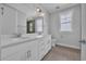 Bathroom with double vanity, white cabinets, and large mirror complemented by neutral wall paint at 1961 Indigo Cove Ln, Calabash, NC 28467