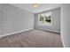 Well-lit bedroom with neutral carpeting, and a window providing natural light at 1961 Indigo Cove Ln, Calabash, NC 28467