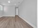 Spacious bedroom with light-colored walls, luxury vinyl plank flooring and two windows for natural light at 1961 Indigo Cove Ln, Calabash, NC 28467