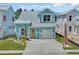 Charming light-blue two-story home with a welcoming yellow door and well-maintained landscaping at 1961 Indigo Cove Ln, Calabash, NC 28467