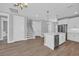 Open-concept space featuring a modern kitchen with an island and bar seating, flowing into a living area at 1961 Indigo Cove Ln, Calabash, NC 28467