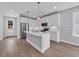 Modern kitchen with white cabinets, stainless steel appliances, island with seating and pendant lighting at 1961 Indigo Cove Ln, Calabash, NC 28467