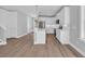 Well-lit kitchen with white cabinets, stainless steel appliances, and an island with bar seating at 1961 Indigo Cove Ln, Calabash, NC 28467