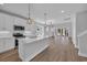 Bright, open kitchen featuring white cabinetry, stainless appliances, and a large island with pendant lighting at 1961 Indigo Cove Ln, Calabash, NC 28467