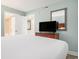 Comfortable bedroom with a flat-screen TV, light-green walls, and white doors at 201 S Ocean Blvd. # 1112, Myrtle Beach, SC 29577