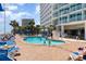Outdoor pool area with lounge chairs surrounded by palm trees at 201 S Ocean Blvd. # 1112, Myrtle Beach, SC 29577