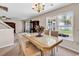 Bright dining area with large windows, chandelier, table, and view to sunroom, ideal for entertaining at 2017 Chadbury Ln., Myrtle Beach, SC 29588