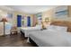 Bedroom featuring two beds with nightstand, accent chair, and beach themed paintings for a relaxing space at 202 74Th Ave. N # 2547/2548, Myrtle Beach, SC 29572