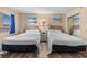 Bedroom featuring two beds, a nightstand, beach paintings and ocean views at 202 74Th Ave. N # 2547/2548, Myrtle Beach, SC 29572