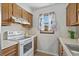 Cozy kitchen featuring white appliances, wood cabinets, and a window bringing in natural light at 202 Millstone Dr., Myrtle Beach, SC 29588