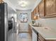 Galley kitchen featuring stainless steel fridge, wood cabinets, and a window bringing in natural light at 202 Millstone Dr., Myrtle Beach, SC 29588