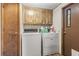 This laundry room features a washer, dryer, wood cabinets and a door to the exterior at 2425 Park St., North Myrtle Beach, SC 29582