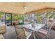A screened-in porch with a ceiling fan and a table, perfect for enjoying the outdoors indoors at 2425 Park St., North Myrtle Beach, SC 29582