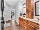 Bathroom with dual vanities, wood cabinets, large mirrors, and access to a walk-in closet; offering ample storage and style at 2441 Hunters Trail, Myrtle Beach, SC 29588