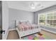Bright bedroom with a white bed frame, colorful bedding, and natural light from a large window at 2441 Hunters Trail, Myrtle Beach, SC 29588