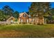 Charming brick home with a well-maintained lawn, professional landscaping, and warm lighting, creating an inviting atmosphere at 2441 Hunters Trail, Myrtle Beach, SC 29588