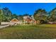 Inviting brick home with a manicured lawn, landscape lighting, and mature trees, showcasing curb appeal at twilight at 2441 Hunters Trail, Myrtle Beach, SC 29588