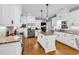 Bright kitchen features white cabinets, stainless appliances, granite countertops, and a central island with pendant lighting at 2441 Hunters Trail, Myrtle Beach, SC 29588