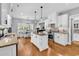 Bright kitchen features white cabinets, stainless appliances, granite countertops, and a central island adjacent to dining area at 2441 Hunters Trail, Myrtle Beach, SC 29588