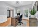 Bright home office with wood floors, a large desk, and natural light from multiple windows at 2441 Hunters Trail, Myrtle Beach, SC 29588