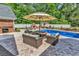 Inviting pool area with outdoor seating, fireplace, and lush landscaping, perfect for relaxing and entertaining at 2441 Hunters Trail, Myrtle Beach, SC 29588