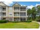 Multi-story building with balconies and a screened porch, surrounded by lush greenery and manicured lawns at 260 Woodlands Way # 2, Calabash, NC 28467