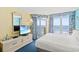 Comfortable bedroom featuring a beachfront view, television, and blue carpet at 2701 S Ocean Blvd. # 902, North Myrtle Beach, SC 29582