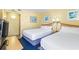 Bright bedroom with two beds, beach themed decor, and adjacent bathroom at 2701 S Ocean Blvd. # 902, North Myrtle Beach, SC 29582