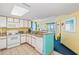 This open kitchen has white cabinets, granite countertops, and is adjacent to the living area with ocean views at 2701 S Ocean Blvd. # 902, North Myrtle Beach, SC 29582