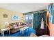 A cozy living room with nautical decor featuring a sliding glass door to the outdoor balcony at 2701 S Ocean Blvd. # 902, North Myrtle Beach, SC 29582