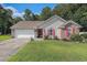 Charming single-story home featuring a well-manicured lawn, brick accents, red shutters, and an attached garage at 271 Sienna Dr., Little River, SC 29566