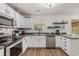 Well-lit kitchen featuring white cabinets, stainless steel appliances, and a modern faucet at 271 Sienna Dr., Little River, SC 29566