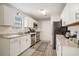 Bright kitchen with white cabinets, stainless steel appliances, granite countertops, and wood-look floors at 2768 Temperance Dr., Myrtle Beach, SC 29577