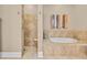 This primary bathroom features a soaking tub and a glass enclosed walk-in shower at 290 Dornoch Dr., Pawleys Island, SC 29585