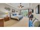 A spacious main bedroom with ceiling fan, custom wall art, and seating for relaxing at 290 Dornoch Dr., Pawleys Island, SC 29585