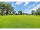 Beautiful golf course featuring green grass, mature trees, landscaping with a sand trap, and blue skies at 290 Dornoch Dr., Pawleys Island, SC 29585