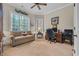 This home office offers a comfortable sofa, ceiling fan, and natural light from two large windows at 290 Dornoch Dr., Pawleys Island, SC 29585