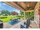 Covered patio featuring tile floors, brick columns, ceiling fans and an outdoor table overlooking the lush green golf course at 290 Dornoch Dr., Pawleys Island, SC 29585