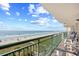 Balcony view of the beach and ocean with railings and patio chairs at 3805 S Ocean Blvd. # 503, North Myrtle Beach, SC 29582
