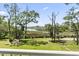 Scenic backyard view of waterfront with green lawn and lush trees under a blue sky at 400 Elizabeth Dr., Murrells Inlet, SC 29576