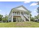 Charming stilt home featuring a spacious porch, well-manicured lawn, and inviting staircase at 400 Elizabeth Dr., Murrells Inlet, SC 29576