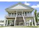 Inviting stilt home featuring a spacious porch, a double staircase, and bright natural lighting at 400 Elizabeth Dr., Murrells Inlet, SC 29576
