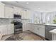 Bright eat-in kitchen featuring white cabinets, stainless steel appliances and a stylish rug on the hardwood floors at 400 Elizabeth Dr., Murrells Inlet, SC 29576