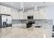 Modern kitchen featuring white cabinetry, stainless steel appliances, granite countertops, and elegant lighting fixtures at 400 Elizabeth Dr., Murrells Inlet, SC 29576