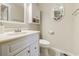 Half bath includes a round mirror, toilet, and vanity with cabinet storage at 415 Ocean Creek Dr. # 2189, Myrtle Beach, SC 29572