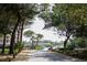 Entrance to the neighborhood shows mature trees, landscaping and a golf cart at 415 Ocean Creek Dr. # 2189, Myrtle Beach, SC 29572