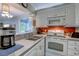 This kitchen has white cabinets and appliances along with a stainless steel sink and an orange backsplash at 415 Ocean Creek Dr. # 2189, Myrtle Beach, SC 29572